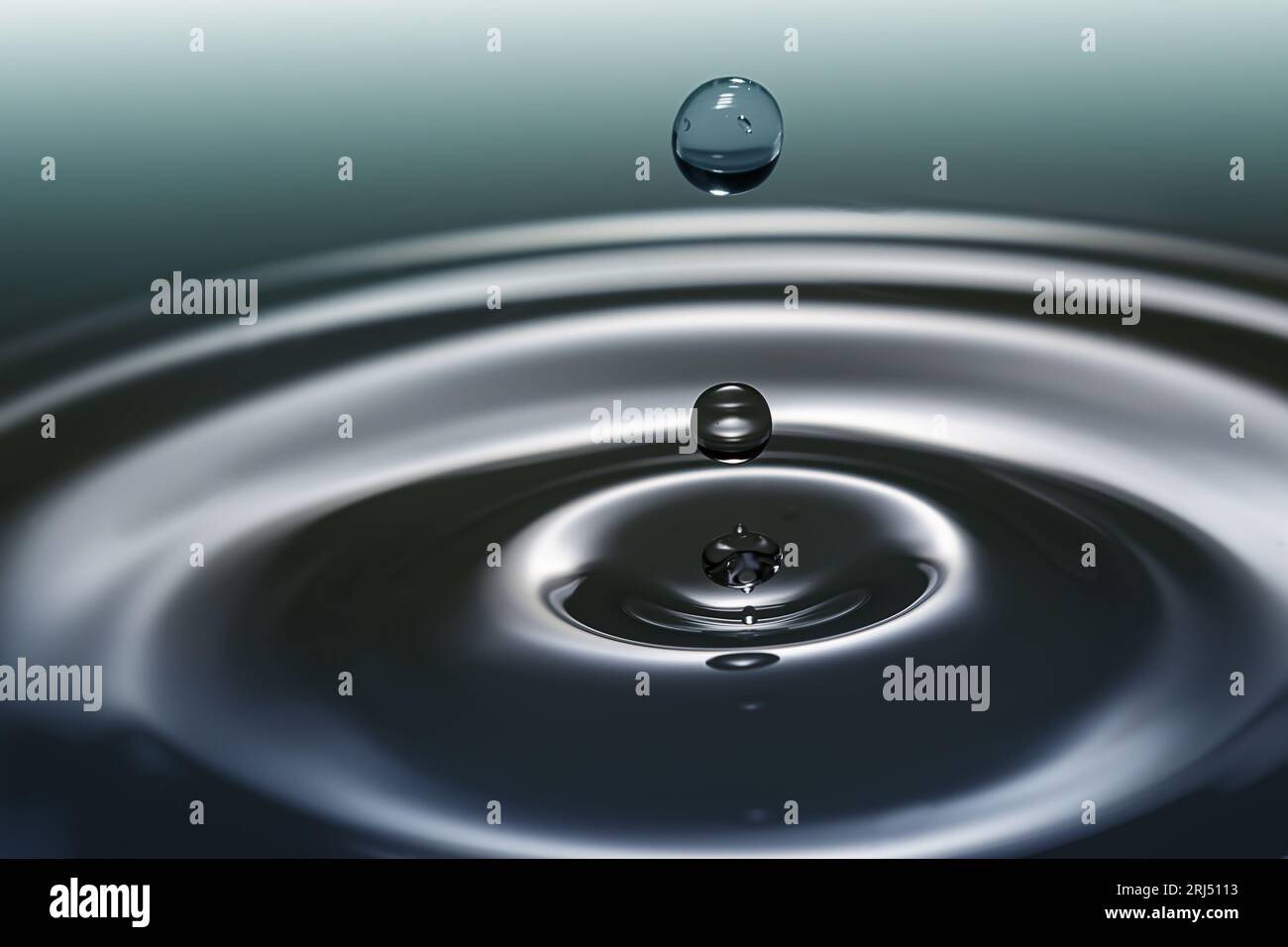 Goutte d'eau d'aqua claire éclaboussant en cercles concentriques, capturant une pureté rafraîchissante. Banque D'Images