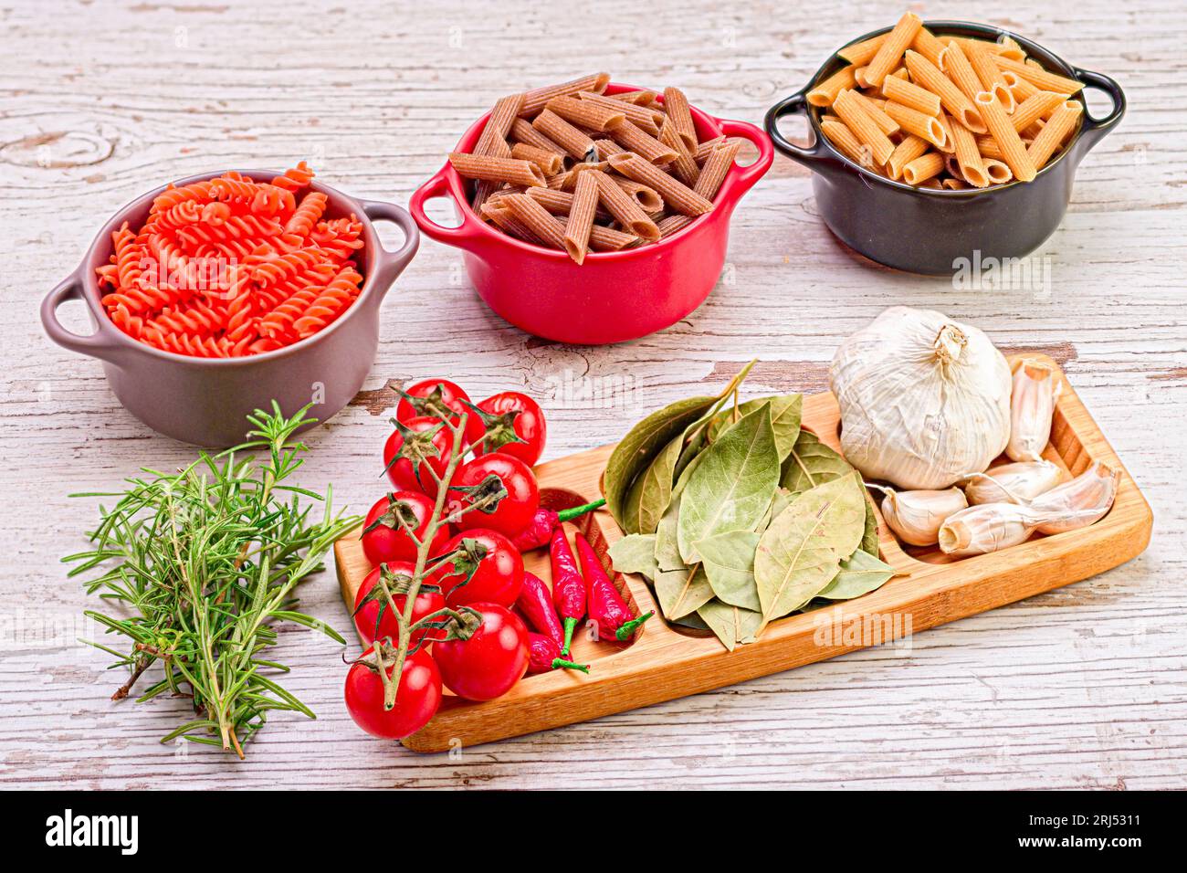 Un plateau en bois rempli d'une variété d'ingrédients frais utilisés dans la cuisine italienne, pâtes, cherr Banque D'Images