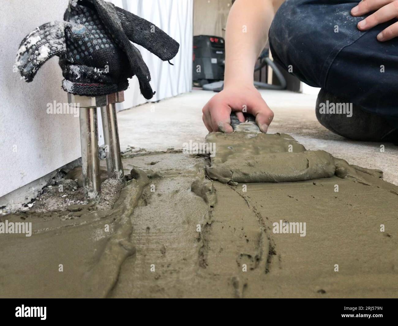 Les mains du constructeur avec une spatule en métal plâtre le mur, verse la chape avec du plâtre, de la colle pour carreaux, du ciment pour la réparation de l'appartement, la construction d'un Hous Banque D'Images