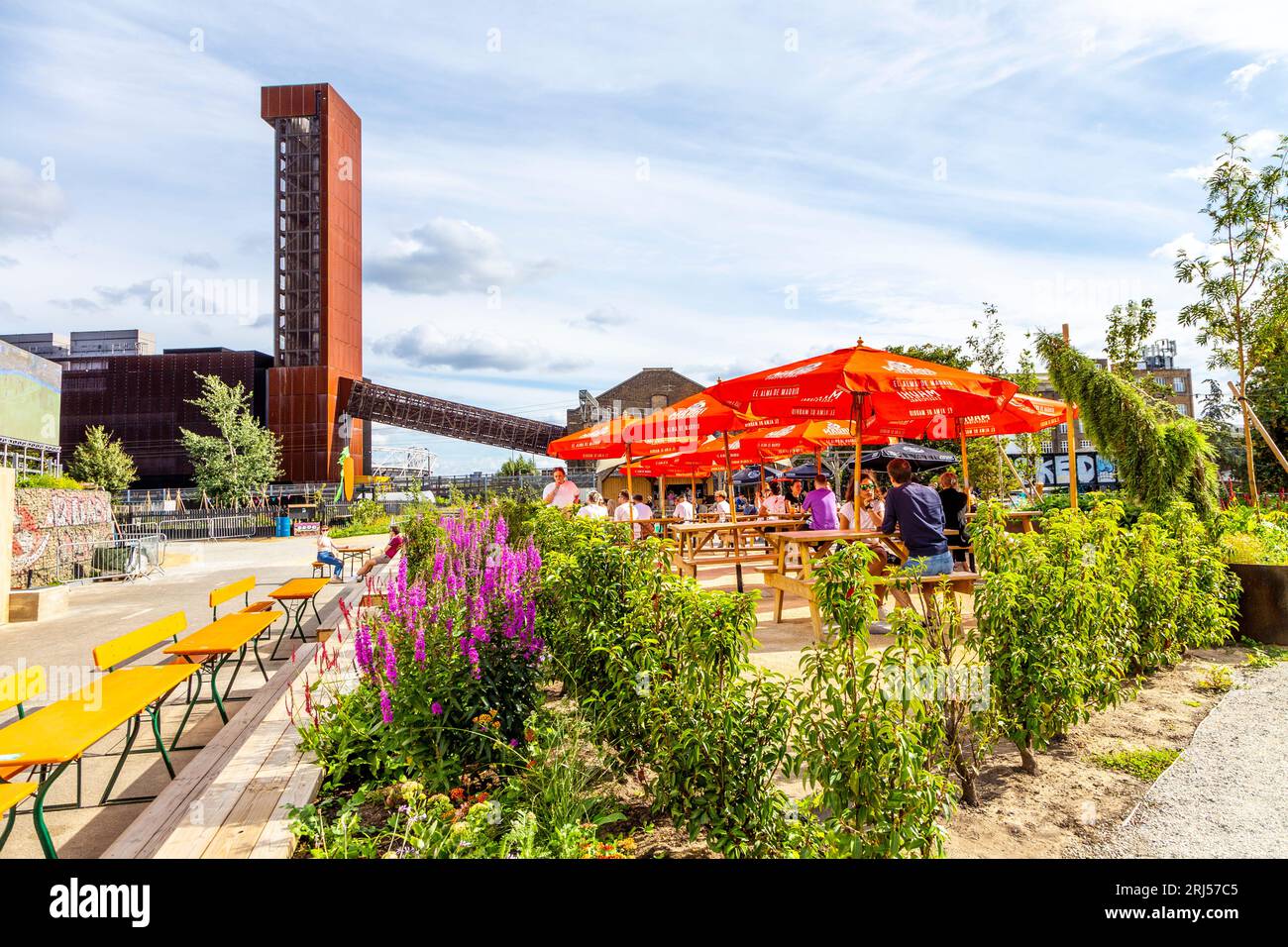 Personnes assises à l'extérieur à l'espace de co-working de Hackney Bridge, au complexe de vente au détail et au marché de la nourriture de rue, Hackney, Londres, Royaume-Uni Banque D'Images