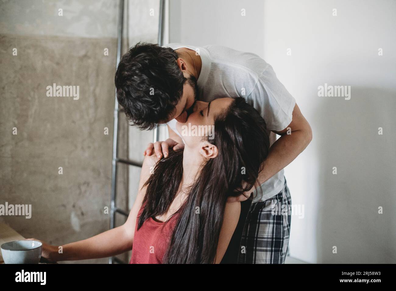 Jeune couple heureux s'embrassant le matin avec leur pyjama Banque D'Images