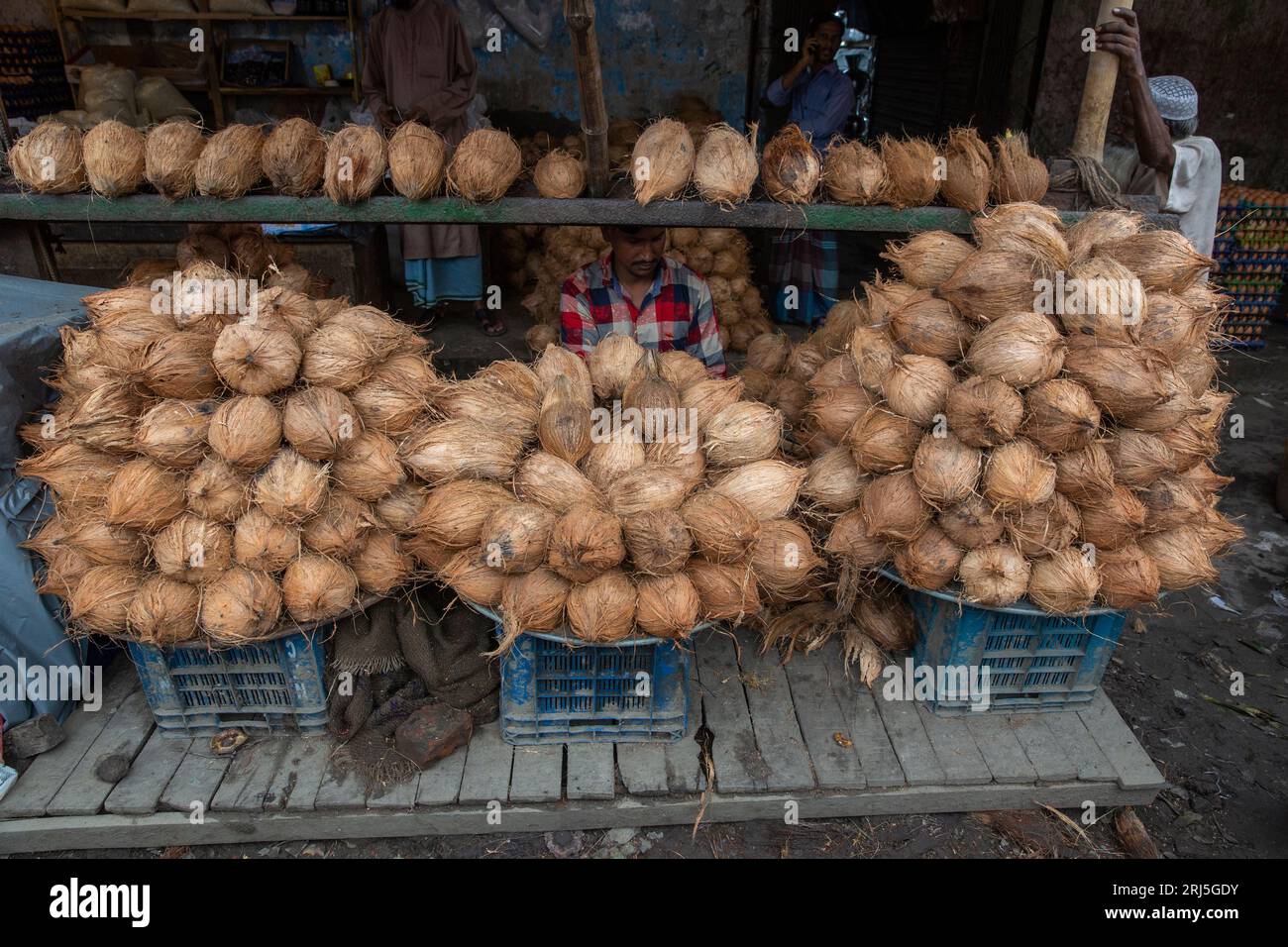 Vendeur de noix de coco au marché de Jurain Railgate où environ 600 colporteurs dirigent leurs entreprises sur les voies ferrées. Les fournisseurs retirent les capots de Banque D'Images