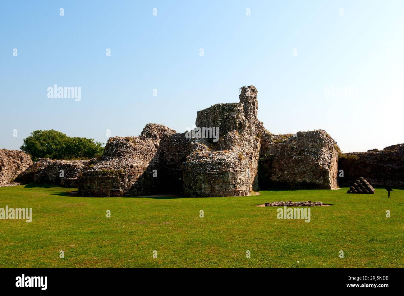 Les ruines du petit donjon roman avec des bastions arrondis monumentaux près du puits et une pyramide de boules de pierre utilisées comme munitions de trébuchet Banque D'Images