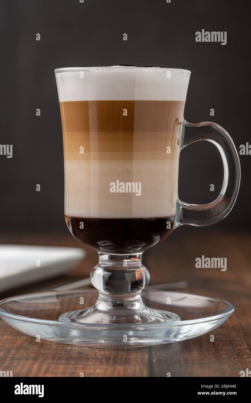 Latte à café multicouche dans une tasse en verre sur une table en bois Banque D'Images