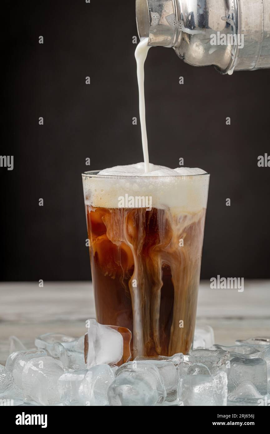 Café glacé latte dans une tasse en verre sur une table en bois Banque D'Images