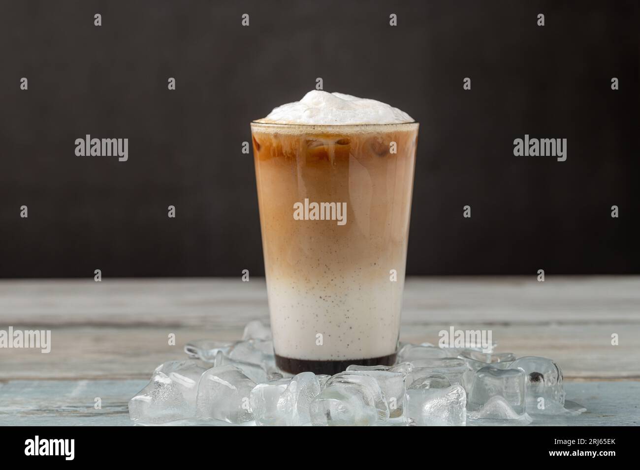 Café glacé latte dans une tasse en verre sur une table en bois Banque D'Images