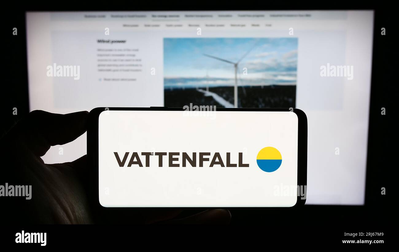 Personne tenant le téléphone portable avec le logo de la société d'énergie suédoise Vattenfall AB sur l'écran en face de la page Web de l'entreprise. Concentrez-vous sur l'affichage du téléphone. Banque D'Images