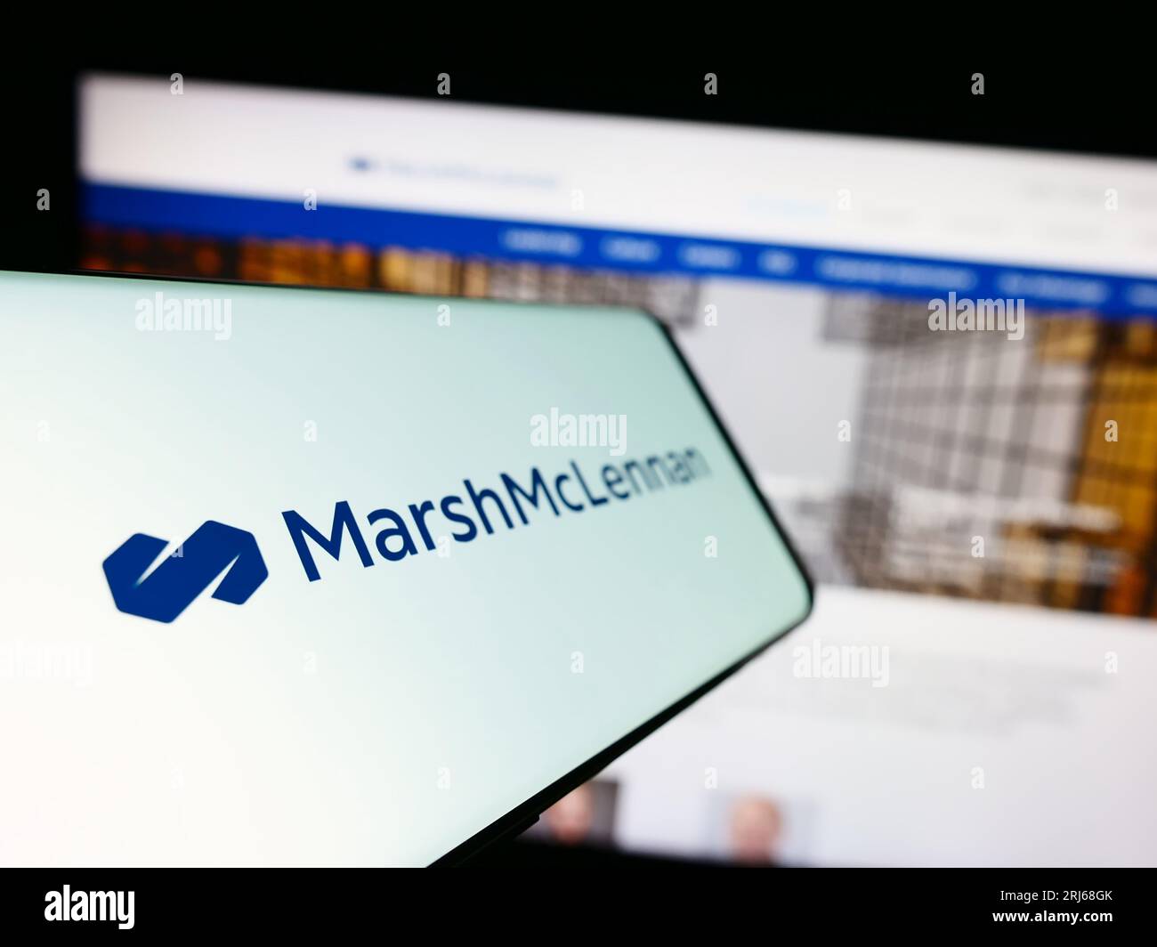 Téléphone mobile avec logo de la société américaine Marsh McLennan Companies Inc. À l'écran devant le site Web de l'entreprise. Effectuez le focus sur la gauche de l'écran du téléphone. Banque D'Images