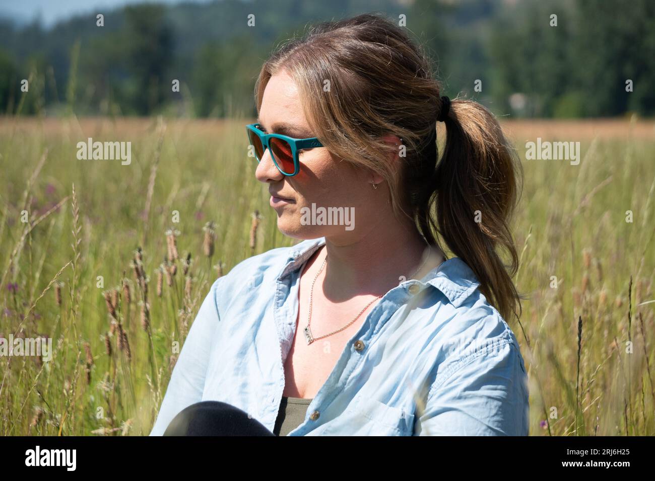 Une femme caucasienne mature debout dans une prairie d'herbe verte luxuriante Banque D'Images