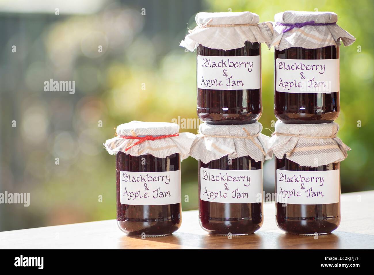 Pots de mûre maison et confiture de pommes. les bocaux ont des étiquettes manuscrites claires et les bocaux ont une garniture en tissu Banque D'Images