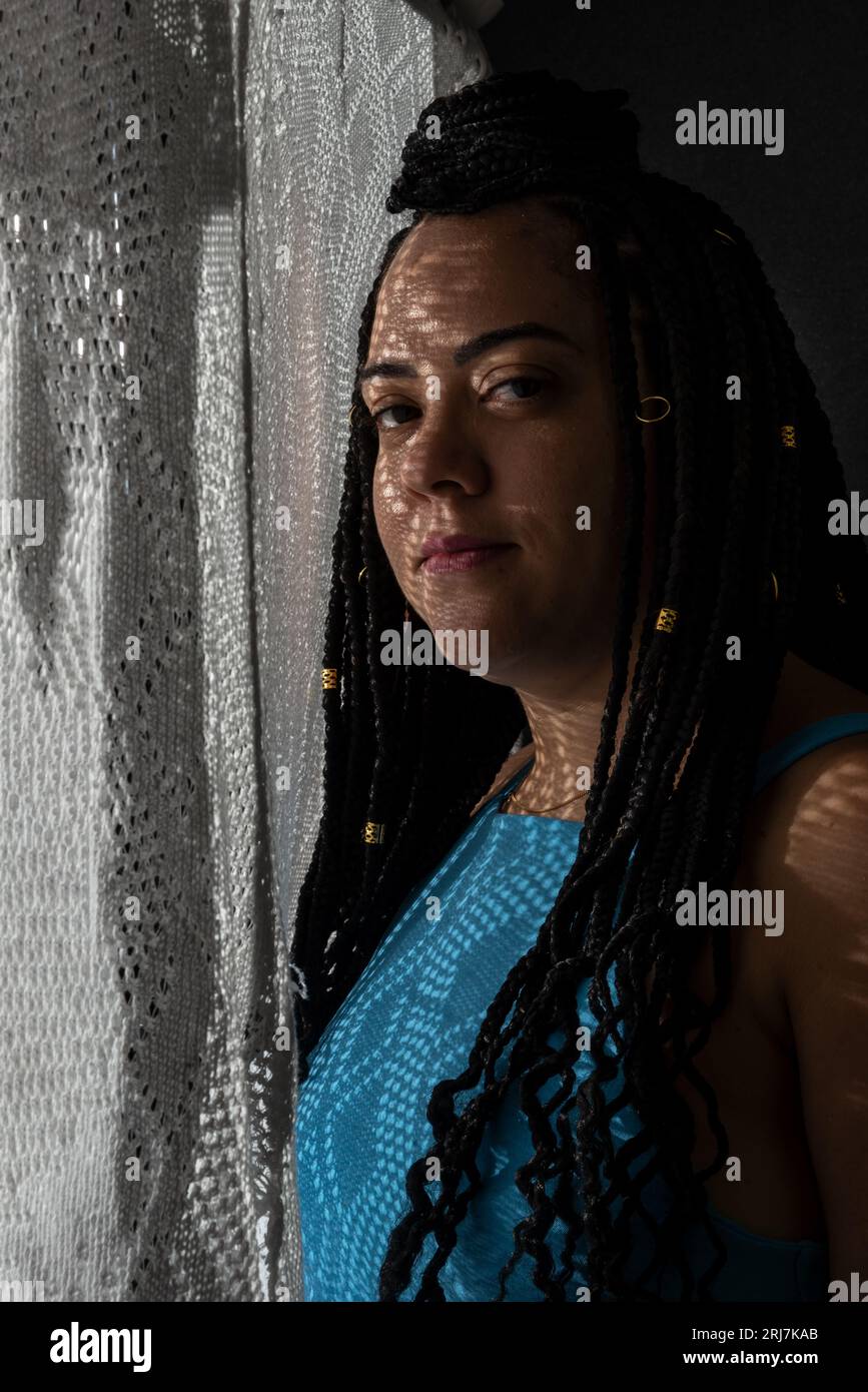 Photo d'une belle femme avec des ombres sur son visage. Portrait de studio avec fond noir. Banque D'Images