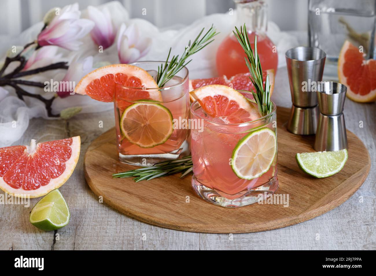 Cocktail bio rafraîchissant avec tranche de pamplemousse, citron vert et branche de romarin dans un verre Banque D'Images