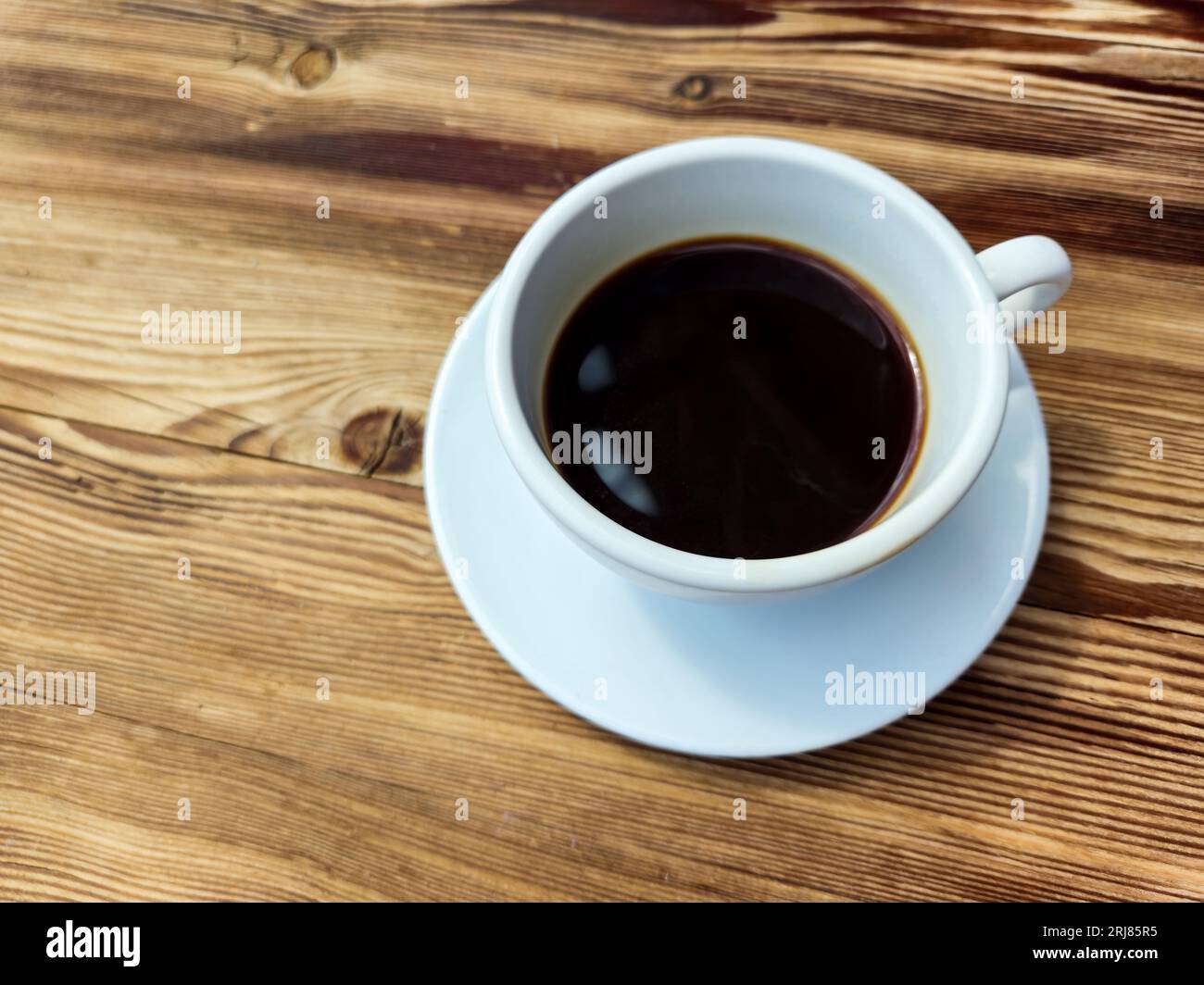 Tasse de café noir sans lait en tasse blanche ronde sur fond de table en bois brun Banque D'Images