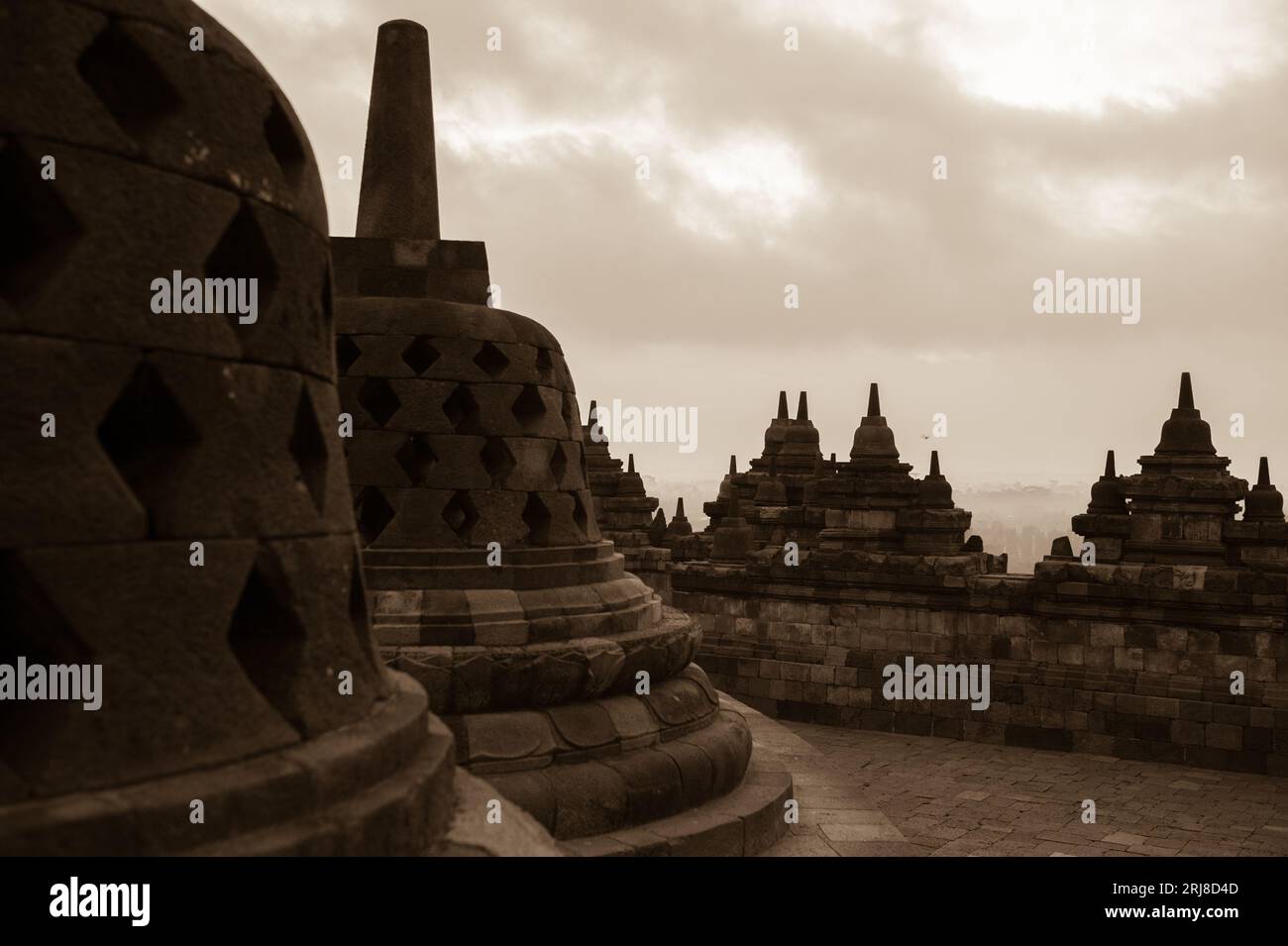 Borobudur à l'aube avec stupa et stupas en arrière-plan. Environnant avec des nuages mous en couleur sépia Banque D'Images