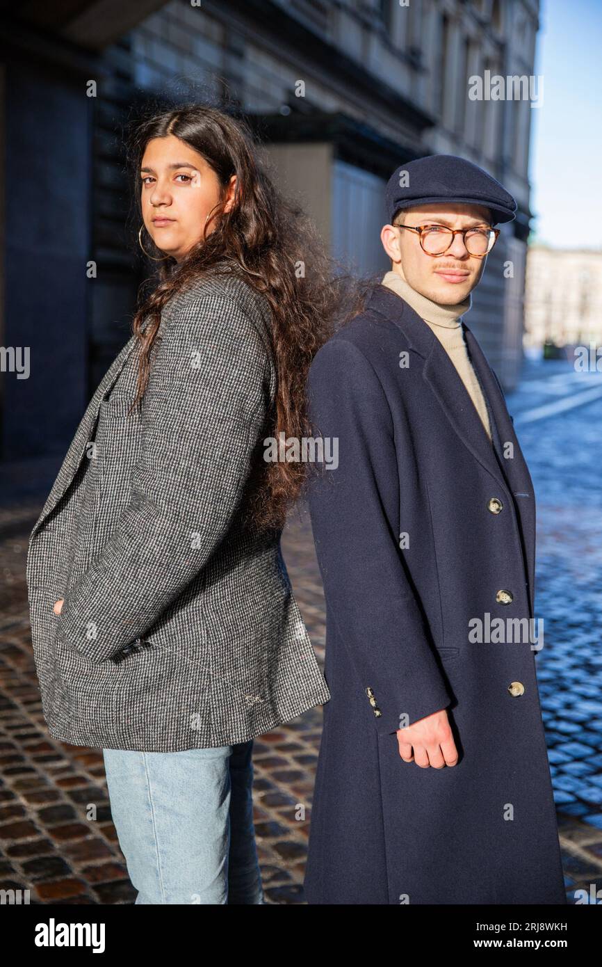 Deux jeunes amis posant dos à dos, femme nord-africaine et homme danois, amitié multiethnique Banque D'Images