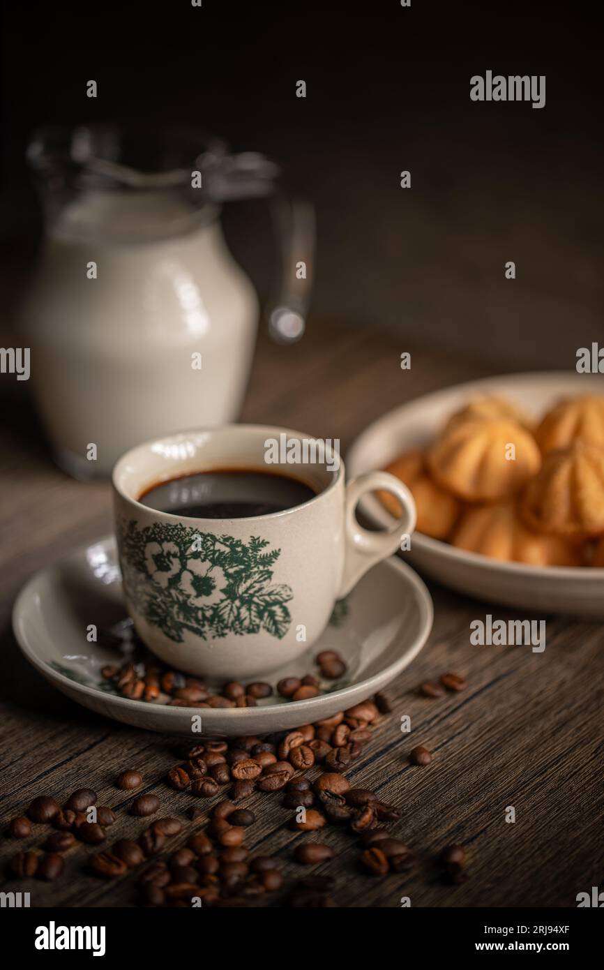 Kuih Bahulu avec une tasse de café sur la table en bois. Snacks malaisiens. Asian Foods. Banque D'Images
