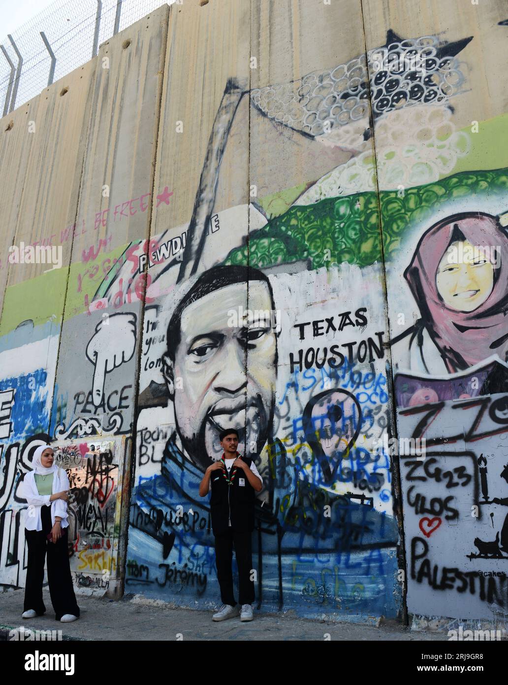 Palesiniens posant près des peintures murales sur la barrière de sécurité israélienne à Bethléem, Palestine. Banque D'Images