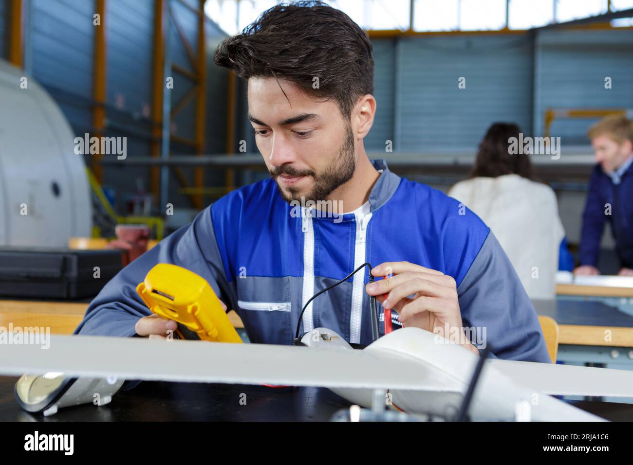 ingénieur aéronautique utilisant un multimètre sur un modèle d'avion Banque D'Images