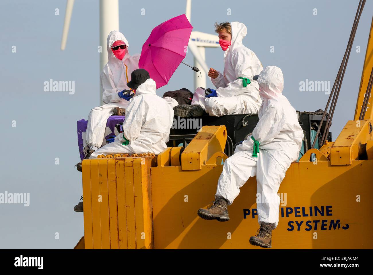 22 août 2023, Schleswig-Holstein, Brunsbüttel : des militants du groupe 'Ende Gelände' se tiennent debout sur l'excavatrice d'un chantier qui doit conduire à un terminal GNL. Depuis le matin, des militants occupent un chantier de construction où des tuyaux pour un gazoduc de GNL doivent être posés. Photo : Bodo Marks/dpa Banque D'Images