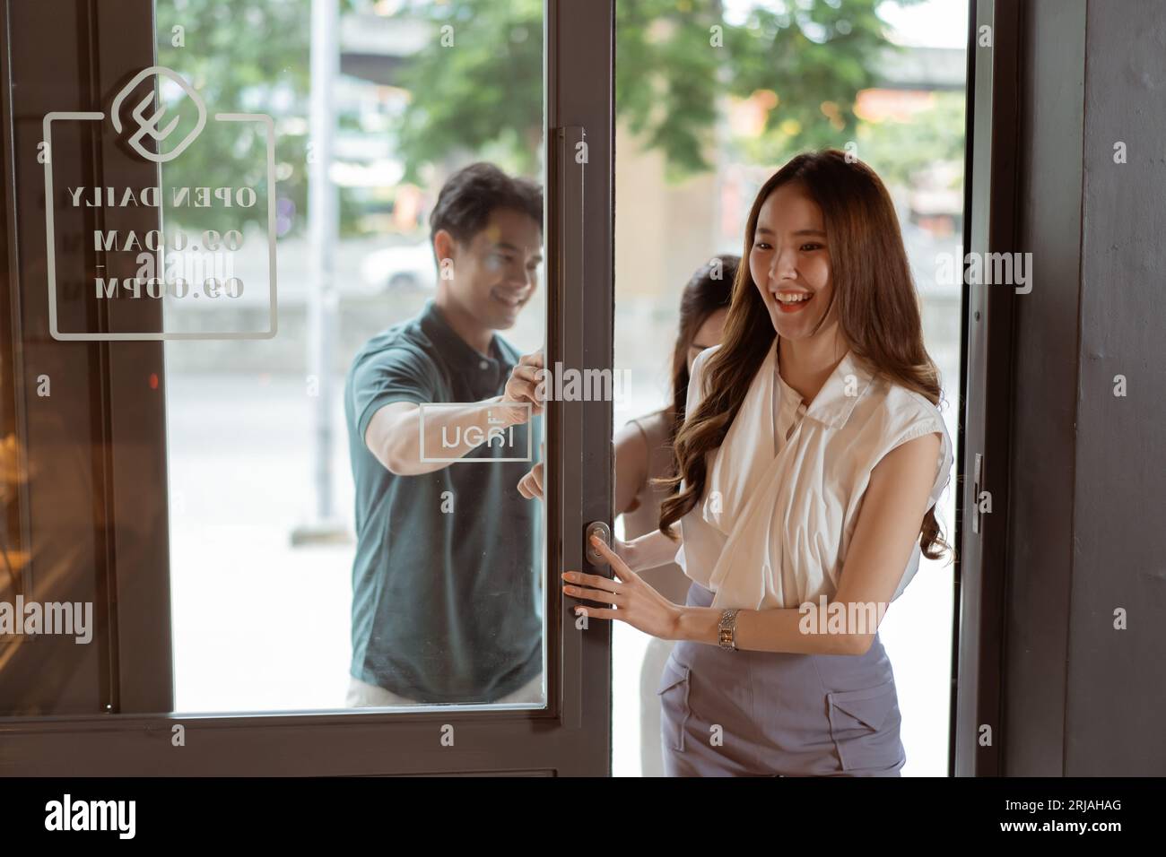 Groupe d'adolescents asiatiques entrant ensemble dans une boulangerie. Homme et femmes visitant un café avec le sourire Banque D'Images