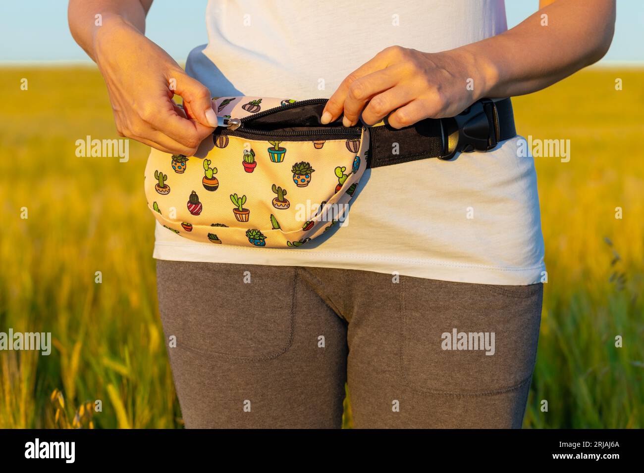femme ouvre le sac de fanny sur la ceinture dans la nature. sac à bandoulière Banque D'Images