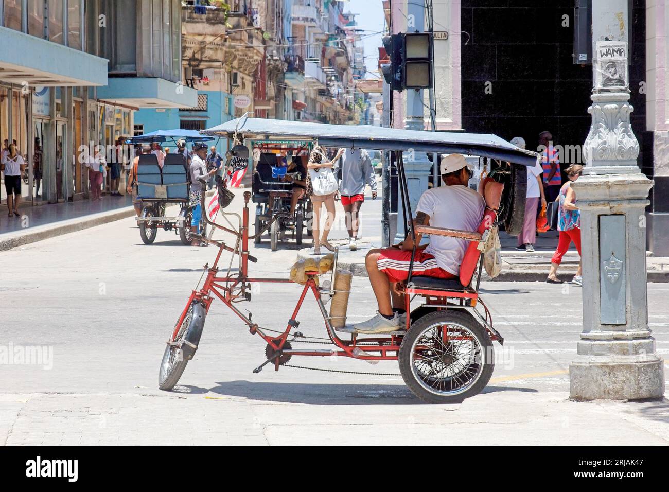 La Havane, Cuba, un homme est assis sur un bicitaxi ou un pousse-pousse attendant les clients. Transport petite entreprise dans la capitale Banque D'Images