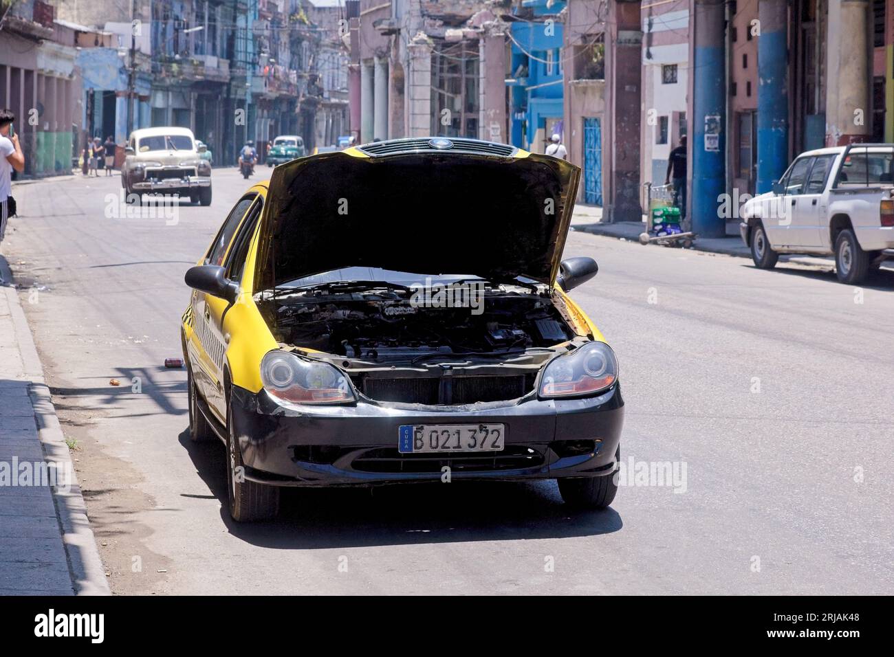 Havana, Cuba, un véhicule Cuba-taxi cassé dans une rue de la ville. Le capot de la voiture est ouvert. Banque D'Images