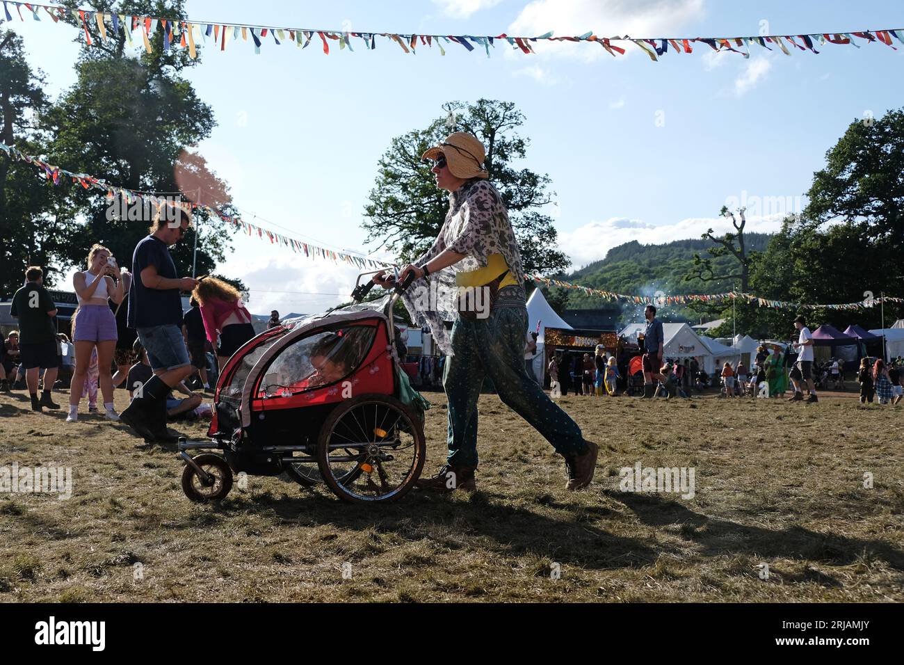 Un parent poussant une poussette pour enfant au festival Greenman, 2023. Banque D'Images