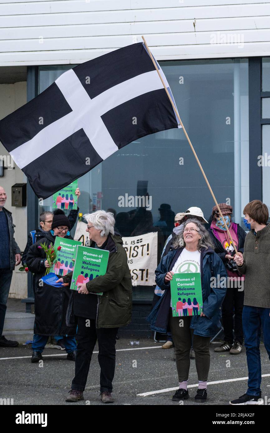 Des manifestants portant le drapeau de St Piran lors d'une manifestation en faveur des demandeurs d'asile vivant temporairement à l'hôtel Beresford de Newquay, en Cornouailles Banque D'Images