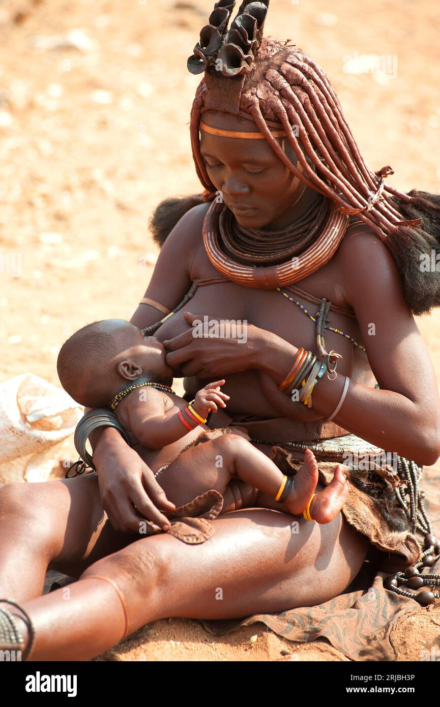 Himba allaitant son fils. Epupa, région de Kunene, Namibie. Banque D'Images