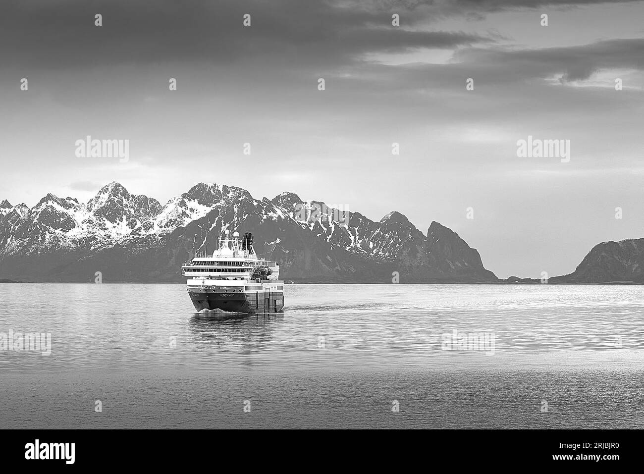 Photo en noir et blanc du ferry norvégien Hurtigruten, MS NORDKAPP, fuyant de Svolvaer, montagnes enneigées des îles Lofoten derrière. Banque D'Images Photo en noir et blanc du ferry norvégien Hurtigruten, MS NORDKAPP, fuyant de Svolvaer, montagnes enneigées des îles Lofoten derrière. Banque D'Images