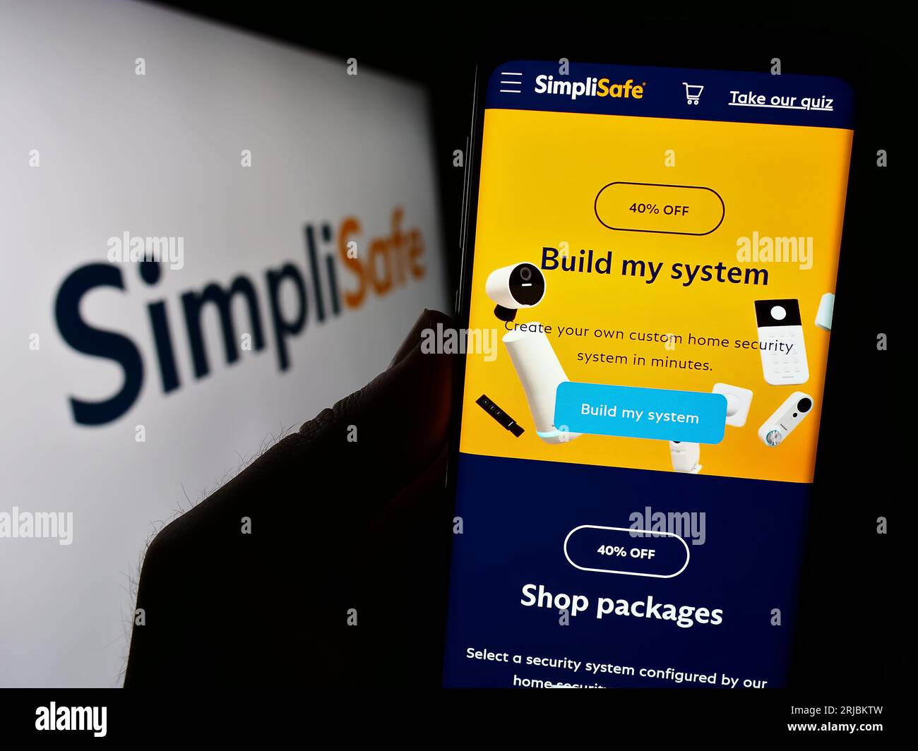 Personne tenant le smartphone avec la page Web de la société américaine de sécurité à domicile SimpliSafe Inc. Sur l'écran en face du logo. Concentrez-vous sur le centre de l'écran du téléphone. Banque D'Images