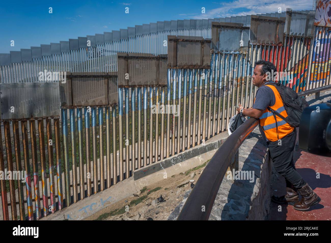 San Diego, États-Unis. 18 août 2023. Un travailleur mexicain regarde le mur frontalier construit aux États-Unis depuis la communauté balnéaire mexicaine de Playas de Tijuana le 18 août 2023. (Matthew Bowler/KPBS/Sipa USA) **AUCUNE VENTE À SAN DIEGO-SAN DIEGO OUT** crédit : SIPA USA/Alamy Live News Banque D'Images