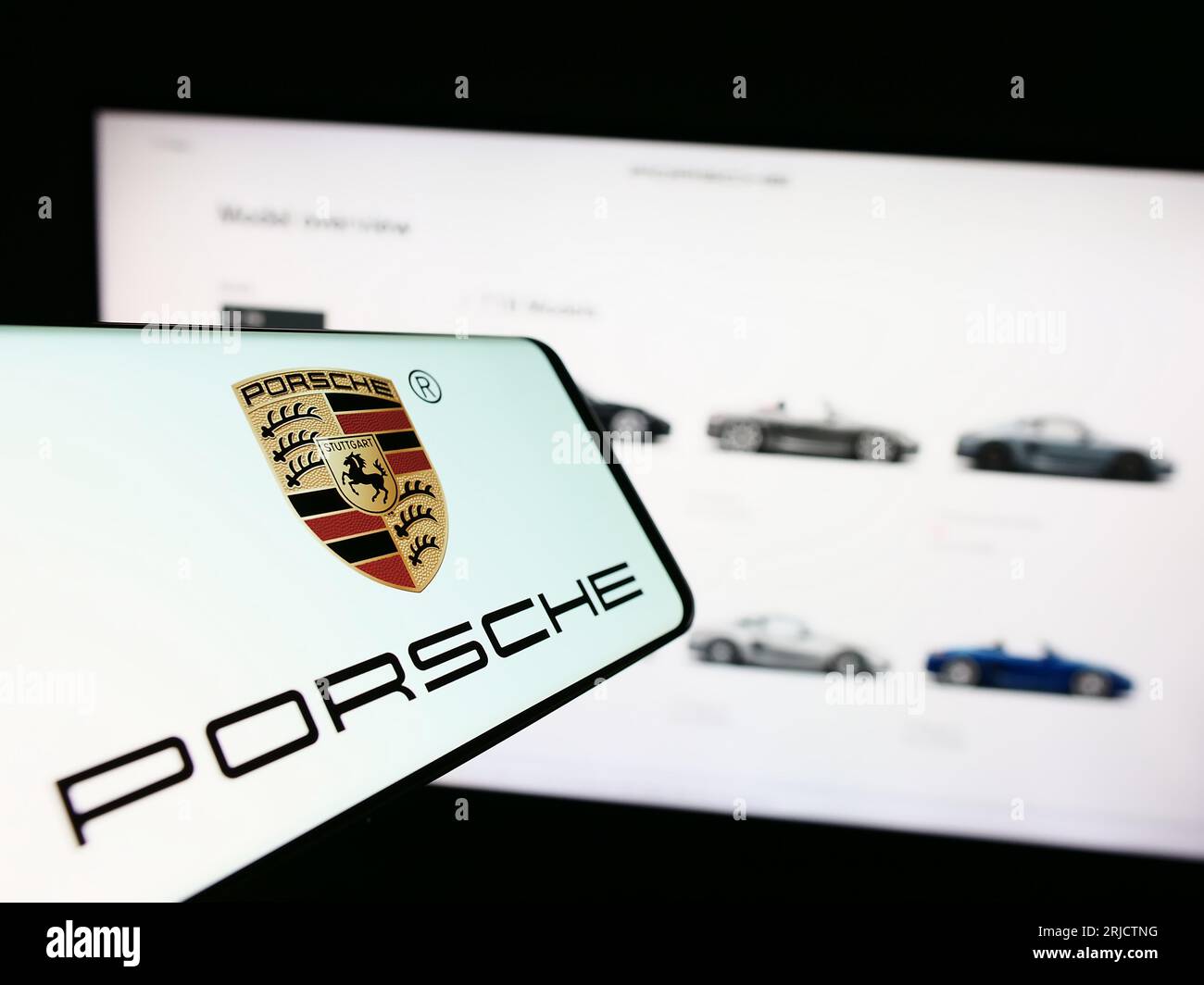 Téléphone portable avec logo de la société automobile Dr. Ing. h.c. F. Porsche AG à l'écran devant le site Web. Concentrez-vous sur le centre de l'écran du téléphone. Banque D'Images
