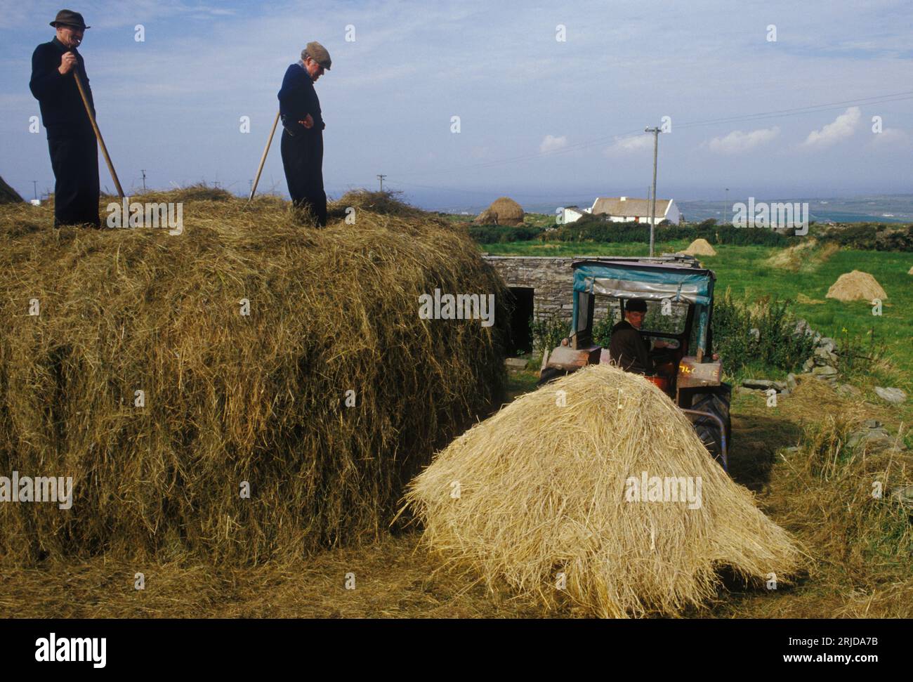 Agriculture rurale côte ouest du sud de l'Irlande des années 1970. Trois agriculteurs construisant une botte de foin.Southern Ireland County Kerry, Eire 1970s. HOMER SYKES. Banque D'Images