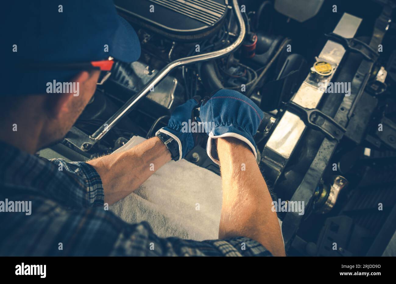 Mécanicien automobile caucasien professionnel effectuant l'entretien du moteur à essence Banque D'Images
