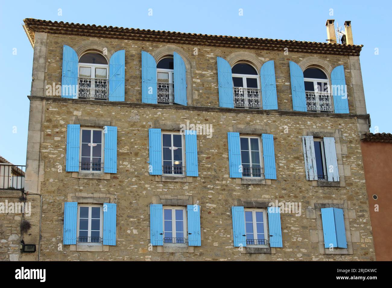 Volets bleus sur l'extérieur d'un immeuble au coeur de Châteauneuf-de-gadagne, Vaucluse, Provence, France. Façade provençale typique Banque D'Images