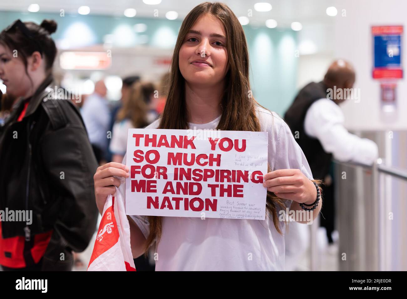 Femme attendant au hall des arrivées T3 de l'aéroport de Londres Heathrow espérant accueillir l'équipe féminine d'Angleterre de football arrivant d'Australie après la coupe du monde Banque D'Images