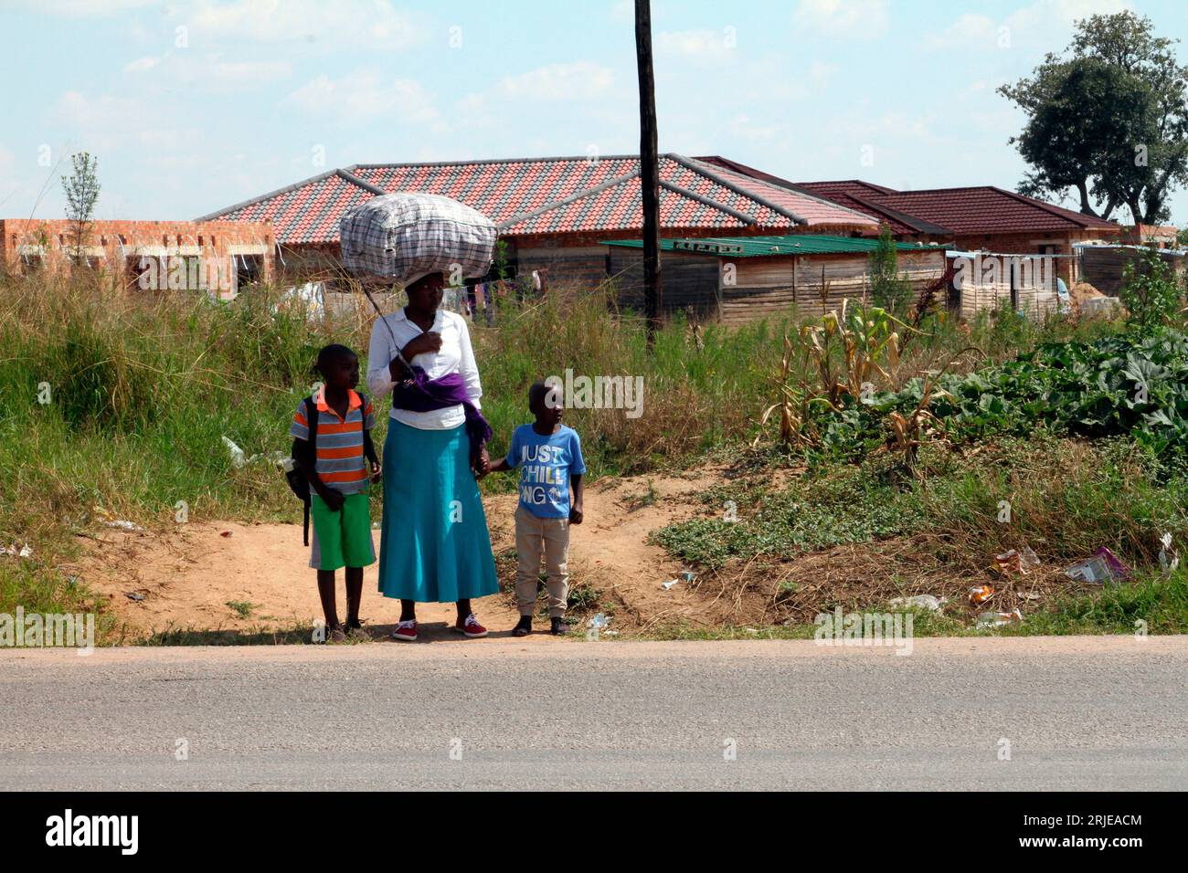 Une femme attend de traverser la route animée Beatrice près de Hopeley Settlement à Harare. La route est l'une des plus fréquentées de la ville, car les véhicules qui se dirigent vers l'Afrique du Sud empruntent cette route. Zimbabwe. Banque D'Images