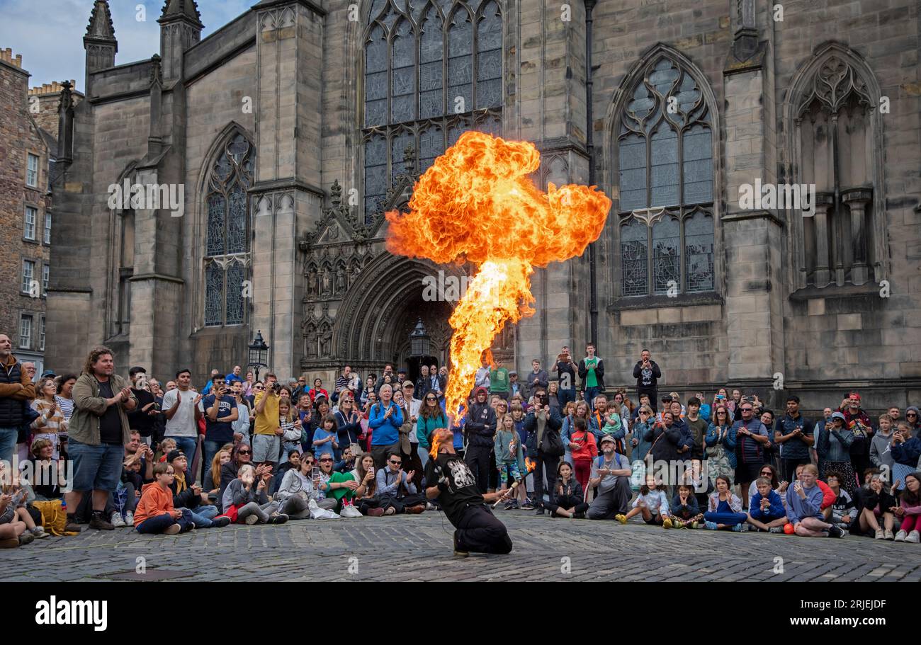 Royal Mile, Édimbourg, Écosse, Royaume-Uni. 22 août 2023. Edinburgh Festival Fringe dernier mardi du festival des arts, le public peut encore être grand, mais pas pour tous les artistes de rue. Nuageux dans la pluie matinale à l'heure du déjeuner puis ensoleillé après-midi. Photo : Chinnen, du Japon, exécute son feu sur la place du Parlement. Crédit : Archwhite/alamy Live News. Banque D'Images