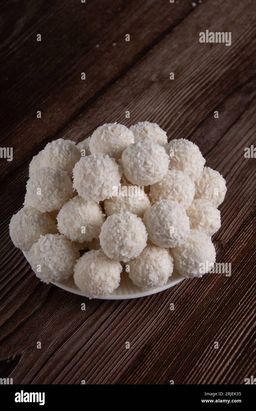 Photo bonbons au chocolat blanc avec garniture à la noix de coco et copeaux de noix de coco. dessert sucré, sucre, boulettes Banque D'Images