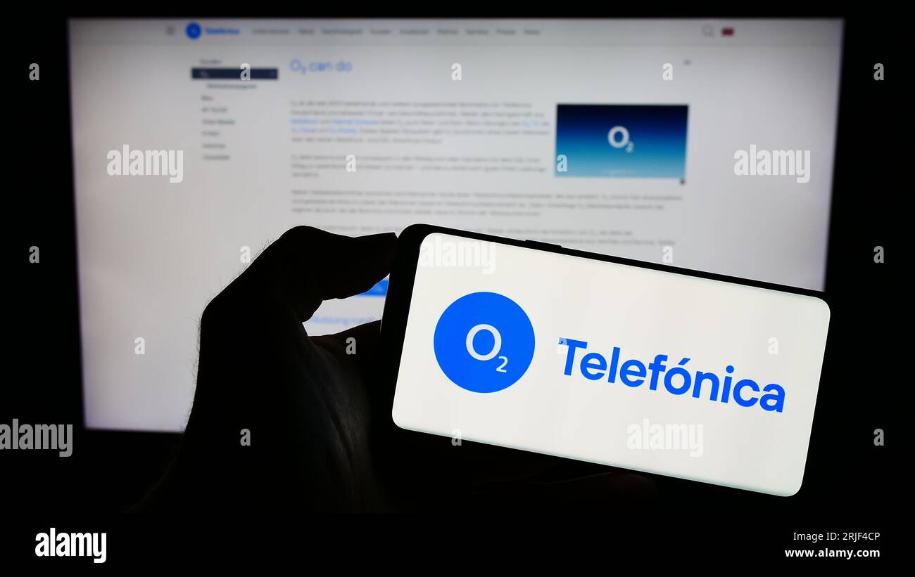 Personne détenant le téléphone portable avec le logo de la société Telefonica Deutschland Holding AG sur l'écran devant la page Web de l'entreprise. Concentrez-vous sur l'affichage du téléphone. Banque D'Images