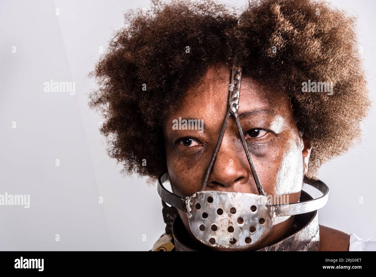 Portrait de visage de femme noire avec masque en fer de l'esclavage couvrant sa bouche. Reproduction en studio. Banque D'Images