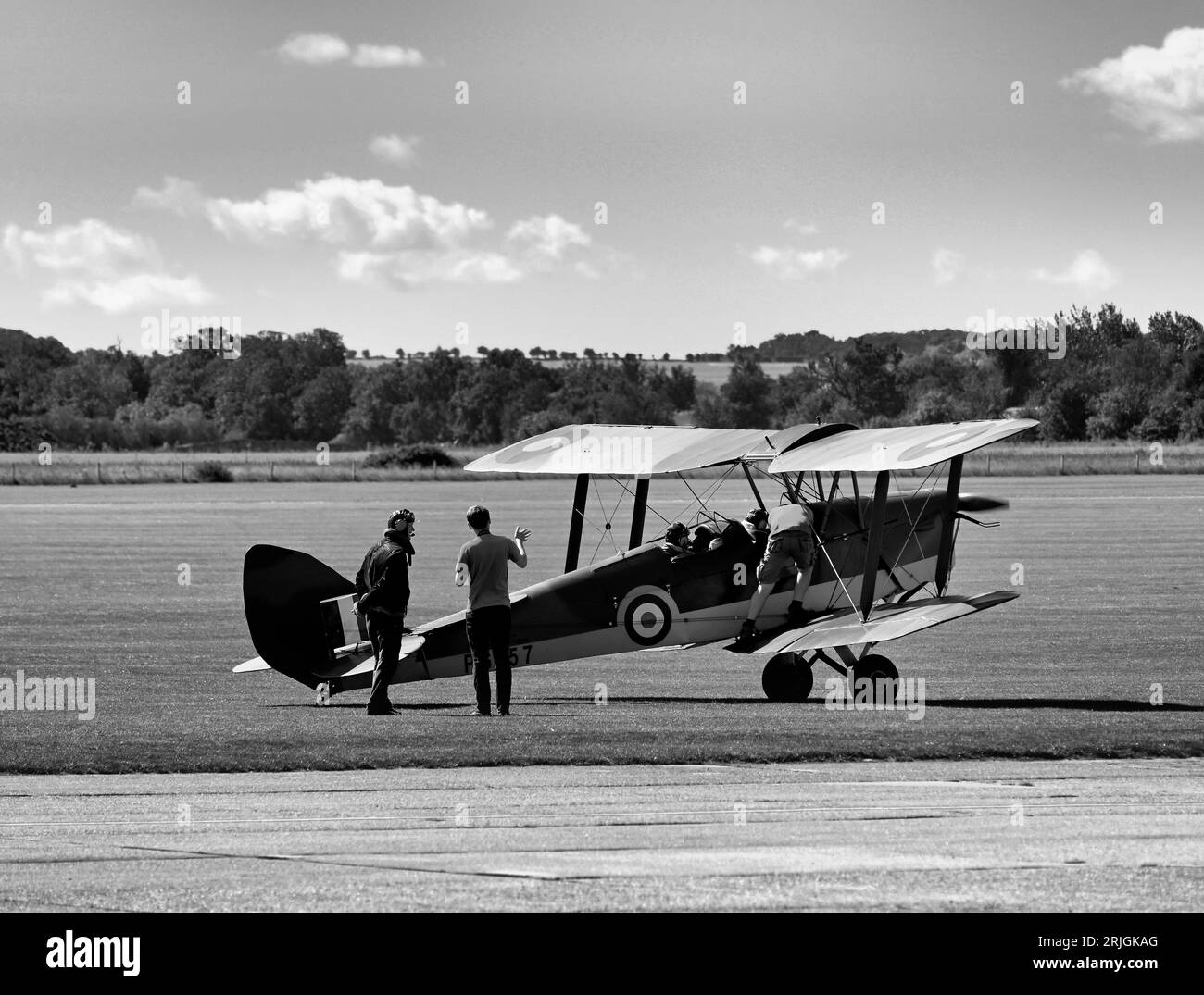 L'avion d'entraînement DH Tiger Moth camouflé de la Seconde Guerre mondiale Classic Wings vient d'atterrir sous un beau soleil à l'Imperial War Museum et à l'aérodrome de Duxford Banque D'Images