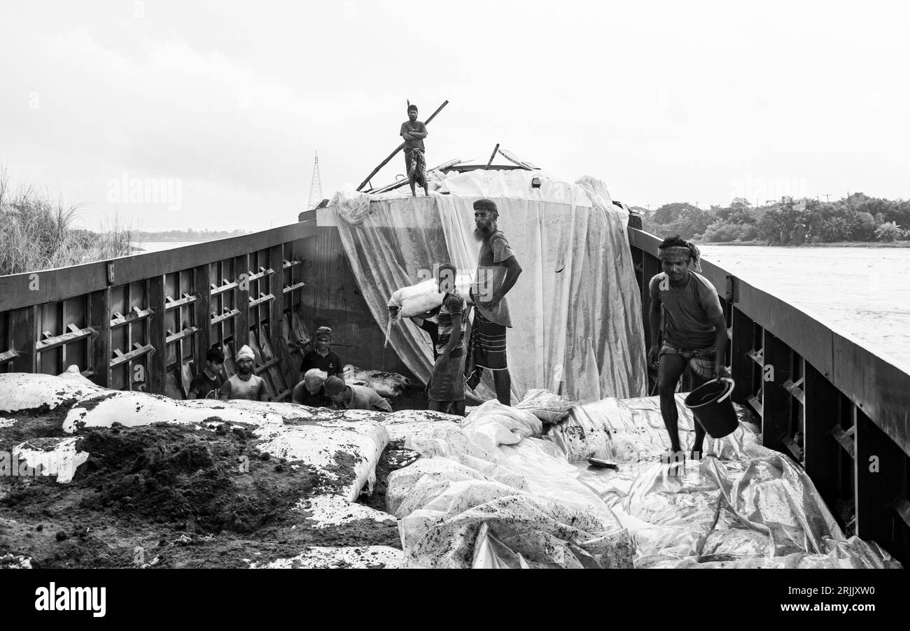 Les coques de bois sont déchargées du bateau. Cette photo a été prise le 14 septembre 2022 à Ruhitpur, Bangladesh Banque D'Images