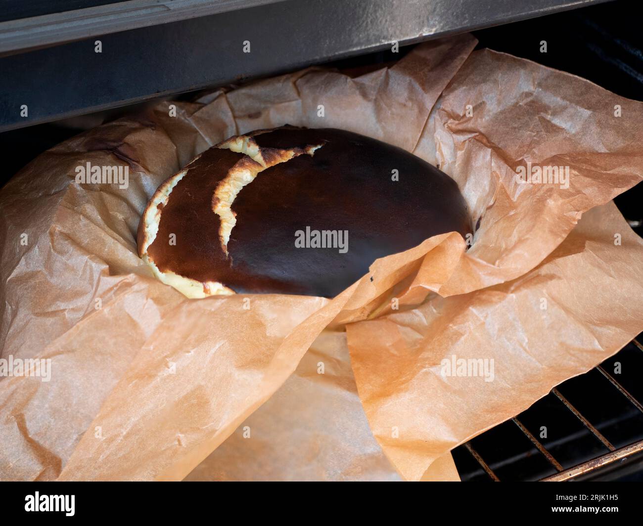 Basque Cheesecake brûlé dans le papier parchemin, prêt à être coupé, plaqué et dévoré. Gâteau au four, mise au point sélective Banque D'Images