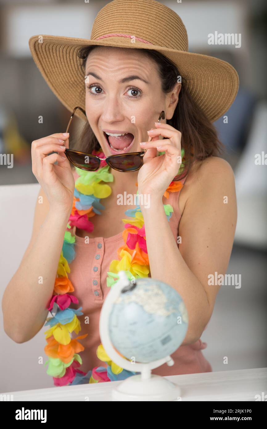 femme excitée par le monde entier mettant sur ses lunettes de soleil Banque D'Images