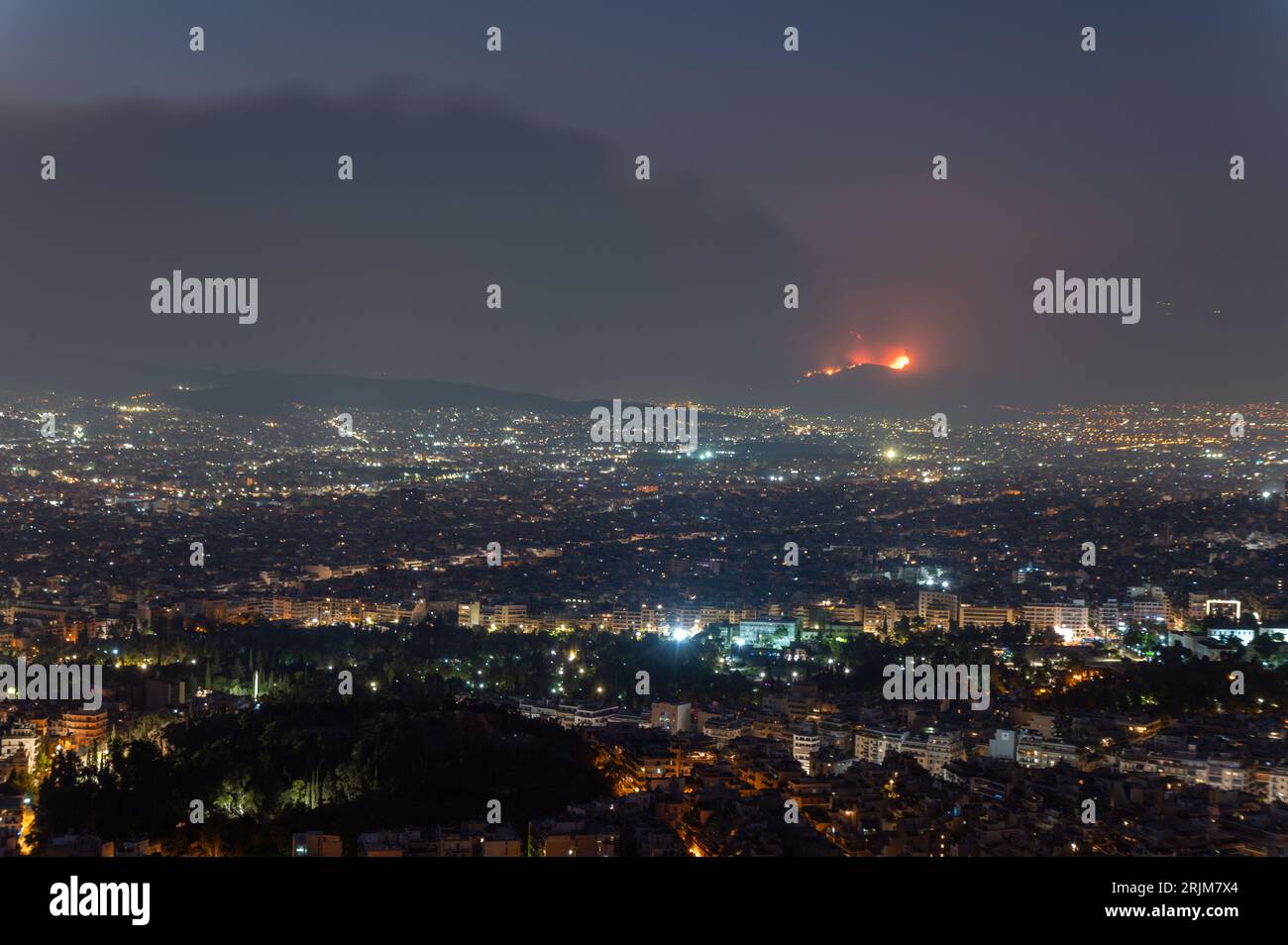 Le 22/08/2023 un feu de forêt a commencé sur les contreforts de la montagne Parnitha dans la banlieue ouest d'Athènes, Grèce. Alimentée par des vents violents, elle a rapidement grandi et brûlé des maisons et des commerces. Cette photo est de Lycabette colline dans le centre d'Athènes regardant vers la montagne. Banque D'Images