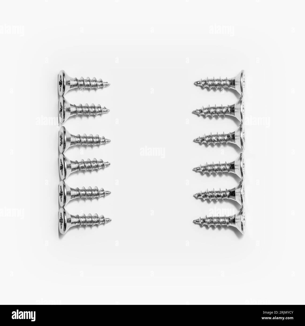 Photographie en studio d'une vis avec des mains croisées sur blanc. Banque D'Images