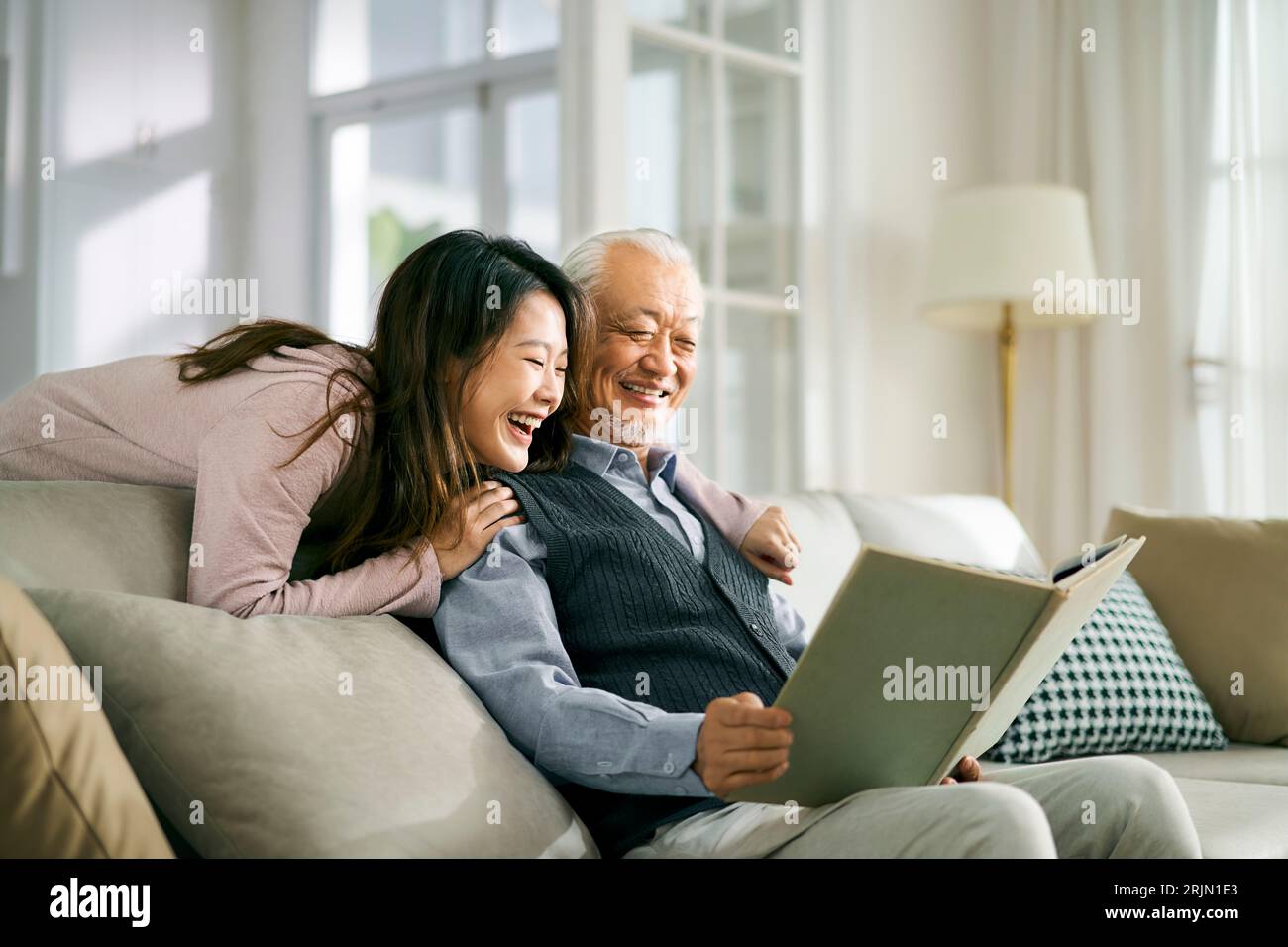 fille adulte asiatique et père aîné appréciant la conversation et le bon temps à la maison Banque D'Images